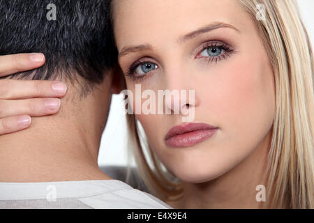 A cute blond comforting her boyfriend. Stock Photo