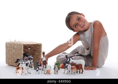 Little girl playing with farm animal toys Stock Photo