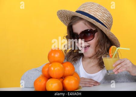 Little girl drinking orange juice Stock Photo