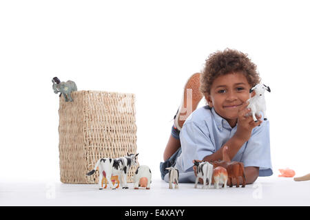 Little boy playing with plastic toy animals Stock Photo