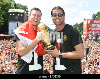 HANDOUT - Germany's Kevin Grosskreutz (L-R) and goal keeper Roman WEIDENFELLER celebrate with the World Cup trophy during the World Cup party at the Brandenburg Gate after team Germany arrived back in Germany in Berlin, Germany, 15 July 2014. The German team won the Brazil 2014 FIFA Soccer World Cup final against Argentina by 1-0 on 13 July 2014, winning the world cup title for the fourth time after 1954, 1974 and 1990. Photo: Markus Gilliar/GES/DFB/dpa (ATTENTION: Editorial use only and mandatory credit 'Photo: Markus Gilliar/GES/DFB/dpa') Stock Photo