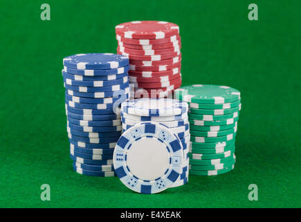 Different casino chips on a green table Stock Photo