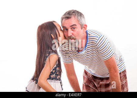 Daughter telling dad a secret, whispering in his ear Stock Photo