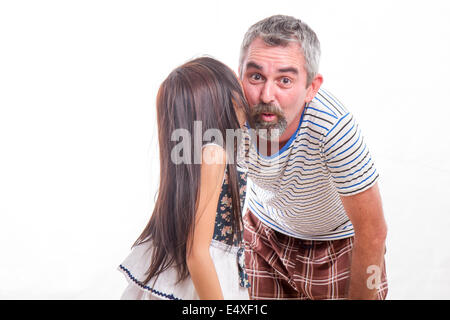 Daughter telling dad a secret, whispering in his ear Stock Photo