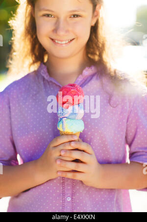 Little smilling girl holding ice cream cone Stock Photo