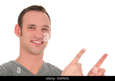 Smiling young man pointing upwards Stock Photo