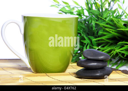 Green mug and spa massage stones Stock Photo