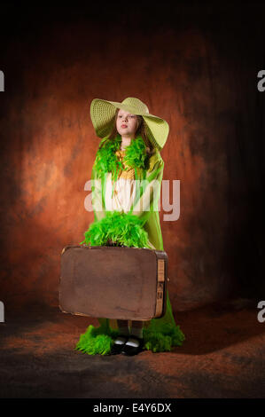Girl in a hat with an old suitcase Stock Photo