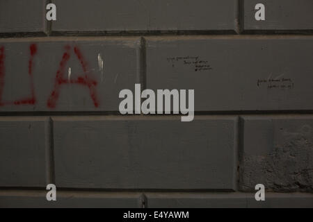 Dark grey brick wall with graffiti Stock Photo