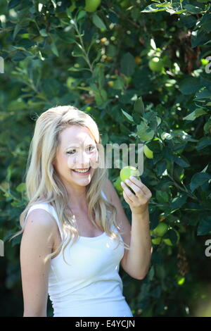 Young woman holding a green apple Stock Photo