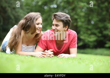 Teenage boy and girl lying on the grass Stock Photo