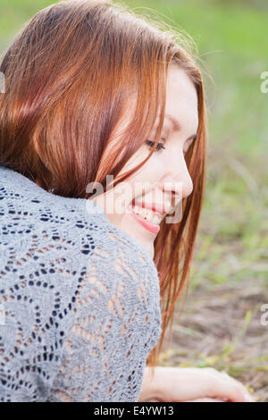 red haired women lying on autumn grass Stock Photo