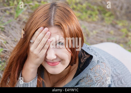 red haired women lying on autumn grass Stock Photo