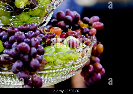 grapes hanging out from crystal dish Stock Photo