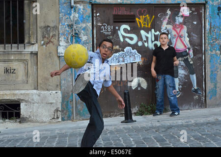 Two Turkish children play football on a quiet street in Beyoglu. Stock Photo