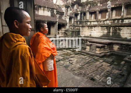 Two Buddhist monks on the outside of the Temple of Angkor Wat. Angkor Wat, in its beauty and state of preservation, is unrivaled Stock Photo