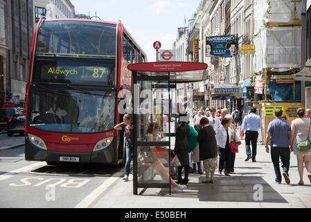 The Strand London UK busy with visitors Red bus at bus stop number 87 bound for the Aldwych Stock Photo