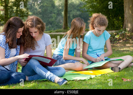 Teenage girls studying together in the park Stock Photo