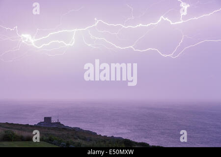 Mayon Lookout, near Land's End, Cornwall, UK. 17 th July, 2014.  Weather: A dramatic electrical storm passes over Cornwall, UK,  during the nation's heatwave, 17th July 2014. Lightning strikes over Mayon Lookout, an old coastguard station situated above Mayon Cliff and between Land's End and Sennen Cove in Cornwall. Numerous lightning strikes lit up the night sky during this spectacular and prolonged display. Credit:  Graham Dunn/Alamy Live News Stock Photo