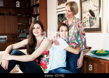 Two women and teenager (16-17) in living room Stock Photo