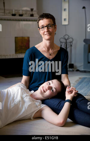 Portrait of mother with daughter (16-17) on floor