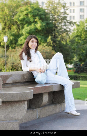 Young woman in a park looking sideway Stock Photo