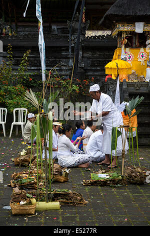 Jatiluwih, Bali, Indonesia.  A Priest Sprinkles Holy Water on Worshipers at the  Luhur Bhujangga Waisnawa Hindu Temple. Stock Photo