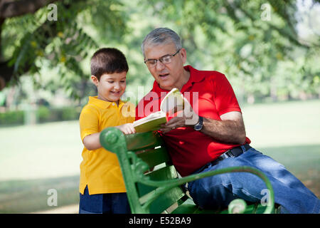 Grandfather and grandson reading a book Stock Photo