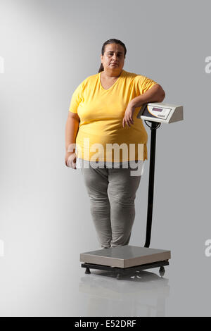 Portrait of obese woman with weighing scale Stock Photo