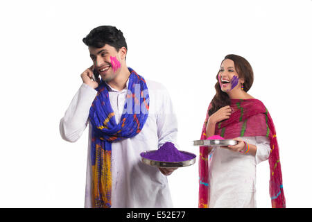 Man with holi colour talking on a mobile phone Stock Photo