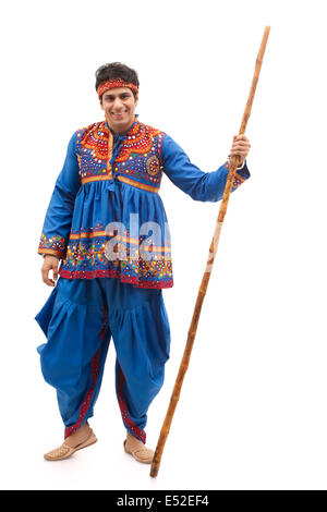 Portrait of happy man in kedia and dhoti performing Dandiya Rass ...