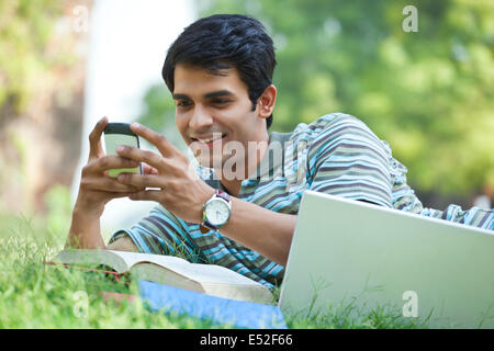Student sending a text message on mobile phone Stock Photo