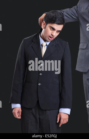 Cropped image of businessmen holding colleague by collar against black background Stock Photo