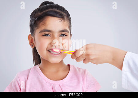 Portrait of little girl getting teeth brushed Stock Photo