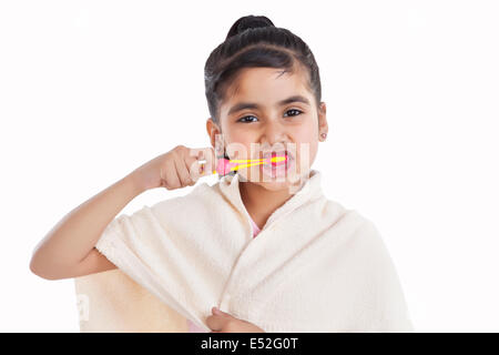 Portrait of little girl brushing her teeth Stock Photo