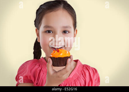 Portrait of a little girl eating a cupcake Stock Photo