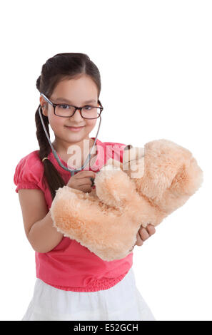 Portrait of little girl playing doctor with teddy bear Stock Photo