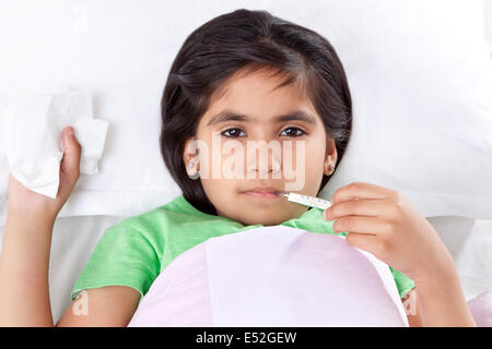 Portrait of little girl with thermometer in mouth Stock Photo
