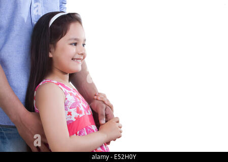 Side view of happy girl holding father's hand against white background Stock Photo