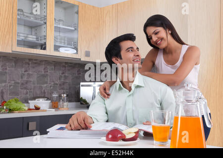 Young Indian couple spending leisure time in kitchen Stock Photo