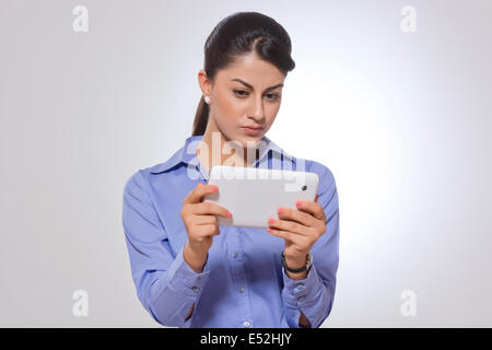 Indian businesswoman using digital tablet against gray background Stock Photo