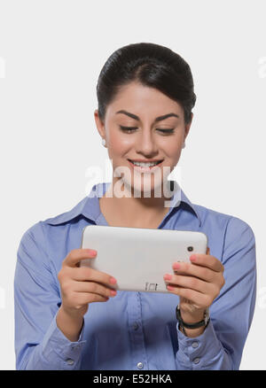 Smiling Indian businesswoman using tablet PC over white background Stock Photo