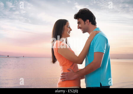 Side view of loving young couple embracing at beach Stock Photo