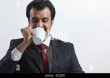Young businessman drinking coffee over white background Stock Photo