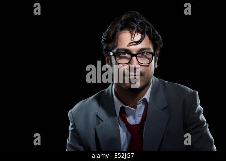 Portrait of young businessman wearing glasses over black background Stock Photo