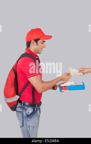 Profile shot of delivery man delivering pizza to customer over gray background Stock Photo
