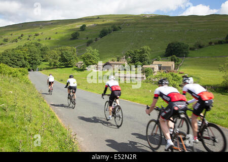 A group of cyclists passing the hamlet of Yockenthwaite, in the Yorkshire Dales National Park, North Yorkshire, England, UK Stock Photo