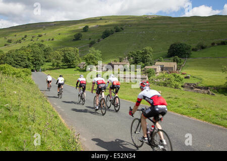 A group of cyclists passing the hamlet of Yockenthwaite, in the Yorkshire Dales National Park, North Yorkshire, England, UK Stock Photo