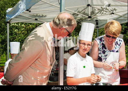 Wiston, West Sussex, UK. 18th July, 2014. HRH Prince Charles chats with children at Wiston House as they prepare lamb burgers under the tutelage of Peter Vaughan [of The Bistro, Devizes,]. The children from local Steyning Primary School's year 5 are taking part in a ‘Chef on the Farm’ day organised by Countryside Classroom. The organisation helps children to connect with where their food comes from. The children work with the gardener to source fresh produce, meet the farmers who rear the sheep, and cook with an expert chef Credit:  Julia Claxton/Alamy Live News Stock Photo