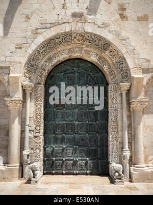 The carved romanesque surround and  bronze doors to The 12th century romanesque Cathedral at Trani, Puglia, Southern Italy. Stock Photo